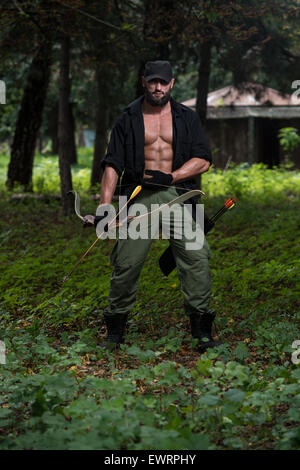 Beard Man With A Bow And Arrows In The Woods Stock Photo