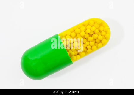 Green and yellow capsule pill on white. Stock Photo