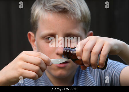 A boy taking antihistamine medicine to help the symptoms of hay fever and allergies Stock Photo