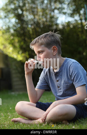 A boy taking antihistamine medicine to help the symptoms of hay fever and allergies Stock Photo