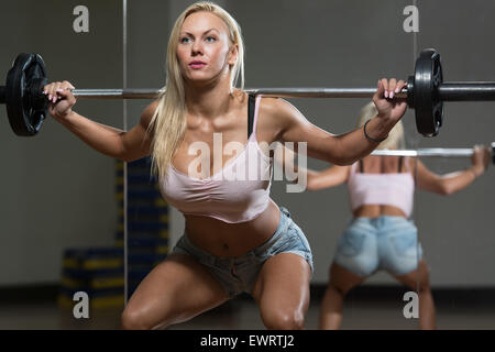 Young Woman Performing Barbell Squats - One Of The Best Body Building Exercise For Legs Stock Photo