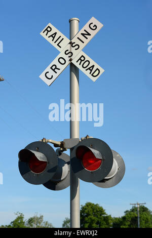 Railroad sign post during daytime with red light on Stock Photo