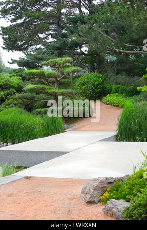 Zig-Zag bridge crossing over a stream leading to a Japanese Garden setting Stock Photo