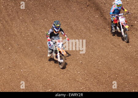 Action adventure Motocross motorcycle race training event. Racing across dirt tracks and leaping in the air, dirt sprays/ Stock Photo