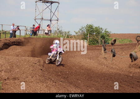 Action adventure Motocross motorcycle race training event. Racing across dirt tracks and leaping in the air, dirt sprays/ Stock Photo