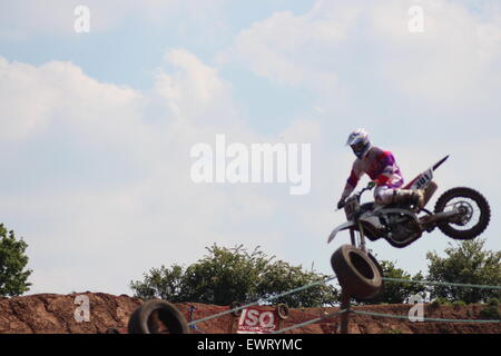 Action adventure Motocross motorcycle race training event. Racing across dirt tracks and leaping in the air, dirt sprays/ Stock Photo