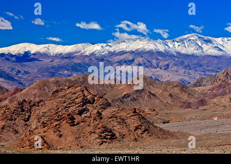Scenic view towards snow covered Panamint Mountains (Sentinel Peak, 9636ft, 2937m) with blue sky and a few clouds above in Death Stock Photo