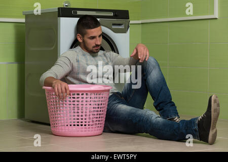 Handsome Young Man In The Laundry Room Stock Photo