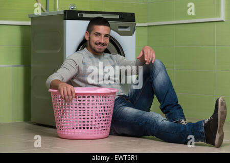 Handsome Young Man In The Laundry Room Stock Photo