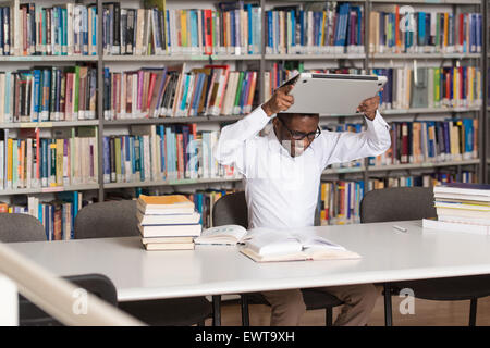 African Male Student Throwing Laptop And Want To Destroy It - Shallow Depth Of Field Stock Photo