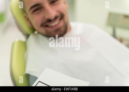 Happy Smiling Patient Says Personal Information While The Dentist Writes On The Card Stock Photo