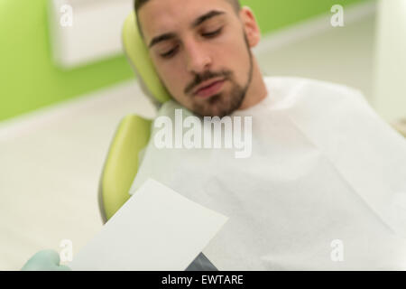 Happy Smiling Patient Says Personal Information While The Dentist Writes On The Card Stock Photo