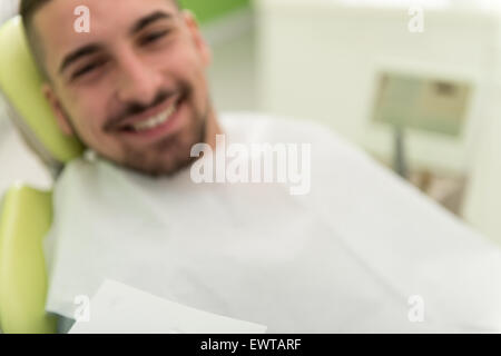 Happy Smiling Patient Says Personal Information While The Dentist Writes On The Card Stock Photo