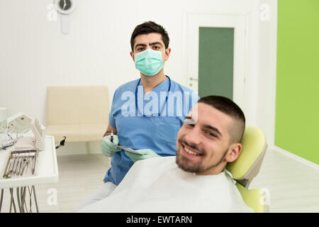 Happy Smiling Patient Says Personal Information While The Dentist Writes On The Card Stock Photo