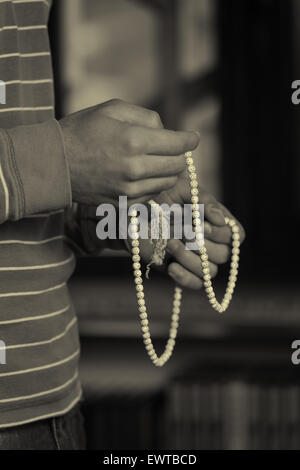 Close-Up Of Young Muslim Man With Rosary Praying In Mosque Stock Photo