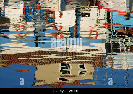 Reflected boats, taverns life-buoys and classical buildings on the sea surface. Myrina quay. Lemnos or limnos island, greece Stock Photo