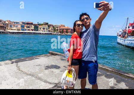 Tourists Taking Selfie on Smartphone Mobil Phone Snapshot Young Couple Happy People Man Woman Old Venetian Port Chania Crete Greece Europe Tourism Stock Photo