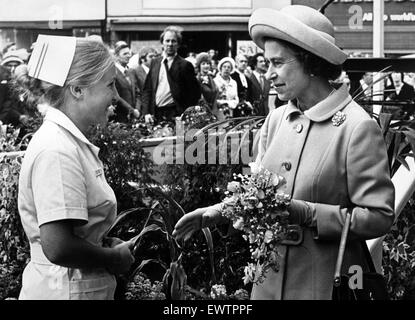 Nurse Susan Laskey presents a bouquet to Queen Elizabeth II as she arrives at Stockton Town Hall during her Silver Jubilee tour. 14th July 1977. Stock Photo