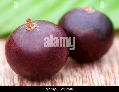 Flacourtia fruits on wooden surface Stock Photo
