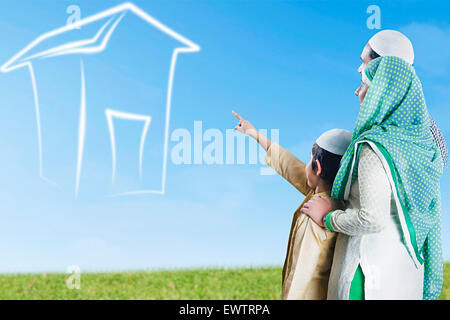 indian Muslim Parents and son park showing house Stock Photo