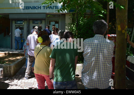 Line of people waiting to withdraw cash from ATM. Banks are closed in Greece and daily limit capital controls are implemented. Stock Photo