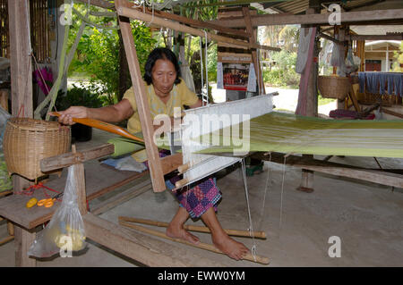 An elderly Tai Dam woman working on old wooden loom, Loei province, Thailand Stock Photo