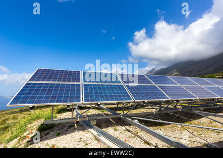 Row of blue solar panels on mountain in greece with blue sky Stock Photo