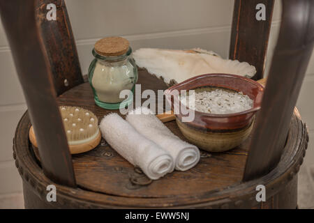Wooden table stand with bath salts, back brush and hand towels Stock Photo