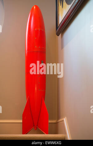 Bold red rocket replica on staircase landing Stock Photo