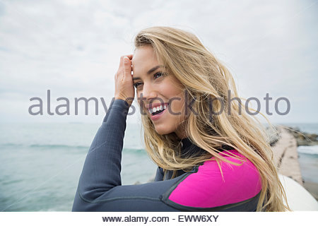 Smiling blonde female surfer at ocean