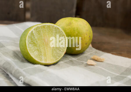 Two limes and cashew on handkerchief prepared to cook focusing on sliced lime and cashew Stock Photo