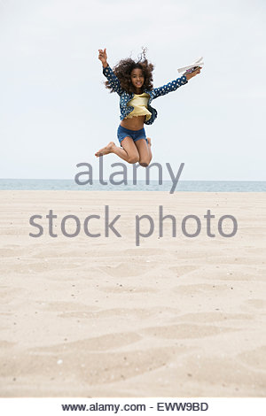 Portrait exuberant girl jumping on beach