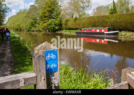 Canal path used by cyclists and walkers. Here hikers walking along path next to Kennet and Avon Canal. Countryside offering a sl Stock Photo