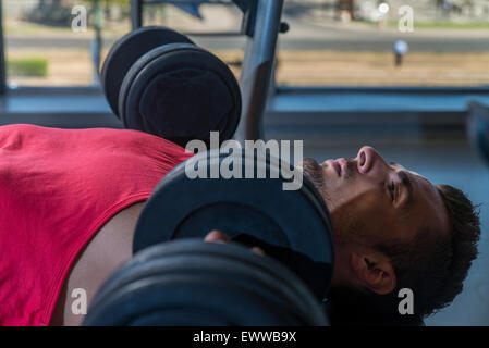 Man Doing Incline Chest Presses With Dumbbells In Gymnasium Stock Photo