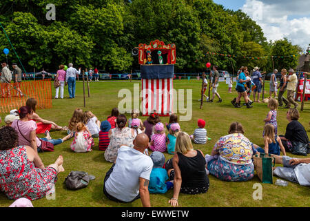 Local Children Watch A Traditional Punch & Judy Show At The Annual Nutley Village Fete, Nutley, Sussex, UK Stock Photo