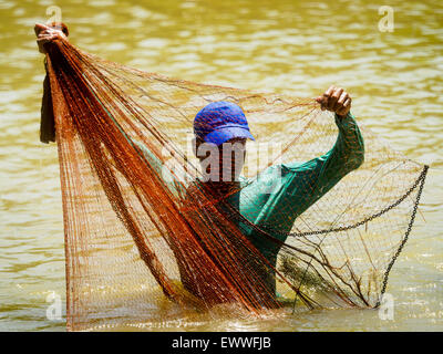 July 1, 2015 - Pa Tan, Lopburi, Thailand - A rice farmer does some subsistence fishing in an irrigation canal in Lopburi province. Normally the canal is too full of fast flowing water for the farmers to fish in it. One farmer said nobody in their community could remember the canal ever being this low. Central Thailand is contending with drought. By one estimate, about 80 percent of Thailand's agricultural land is in drought like conditions and farmers have been told to stop planting new acreage of rice, the area's principal cash crop. Water in reservoirs are below 10 percent of their capacity, Stock Photo