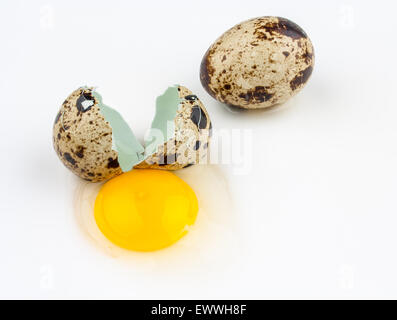 Two broken quail eggs on white background, top view Stock Photo