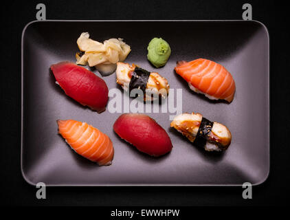 Tuna, salmon and eel sushi on black plate, top view Stock Photo