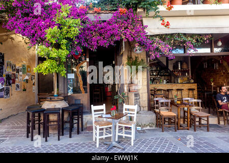 Crete Chania bar Crete cafe under flowers, Chania Old Town street Crete Greece Bougainvillea Magenta Stock Photo