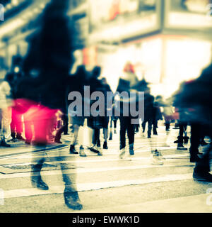 Blurred image of people moving in crowded night city street. Art toning abstract urban background. Hong Kong Stock Photo