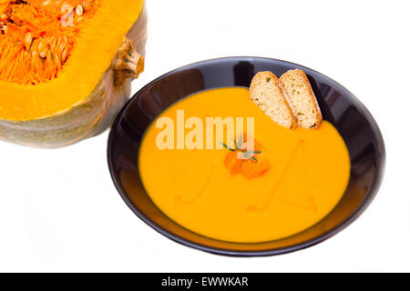 Cream of pumpkin soup with pumpkin nearby on a white background Stock Photo