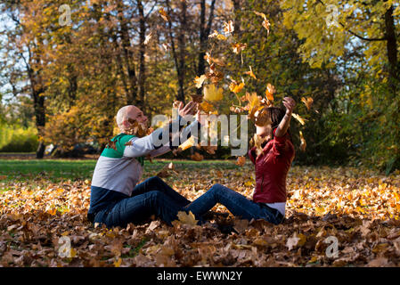 Young Couple Throwing Fall Leaves Stock Photo