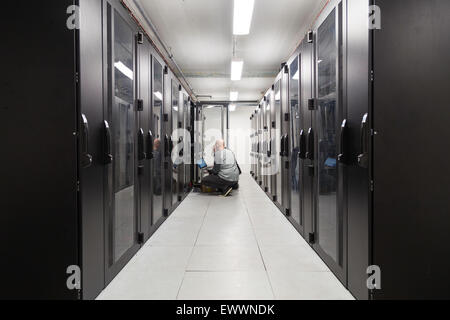 Server specialists working on servers in a server room Stock Photo