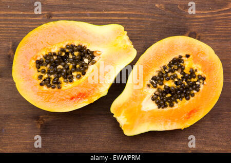 Papaya cut in half on wooden table top view Stock Photo