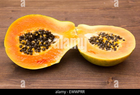 Papaya cut in half on wooden table Stock Photo