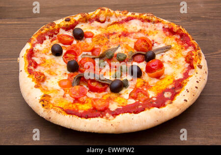 Pizza with anchovies and olives on wooden table Stock Photo