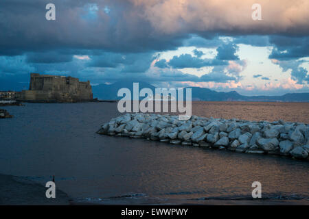view of the gulf of naples and castel dell'ovo on a cloudy evening Stock Photo