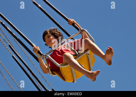Boy riding a sky ride at an amusement park. Stock Photo