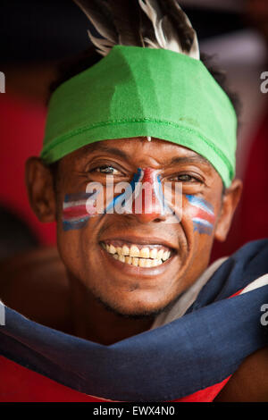 A fanatical Tico football fan with national colours face painted celebrates his country's world cup win in Tamarindo, Costa Rica Stock Photo