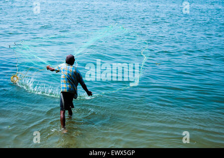 Traditional fishing in Southern India - Fisherman with fishing net at Blue Water, backwaters Kochi (Cochin), Kerala, India Stock Photo